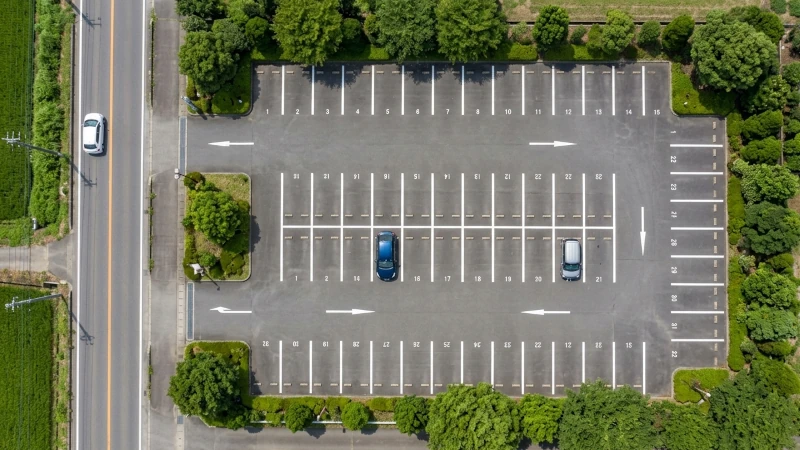 道路脇にある約30台収容の舗装駐車場を真上から見下ろしたイメージ画像。広い駐車スペースに車が2台だけ停まっており、空きが多い様子がわかる